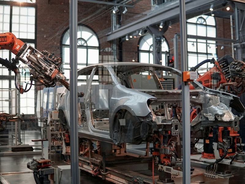 Karosserie am Fertigungsband, daneben Industrieroboter